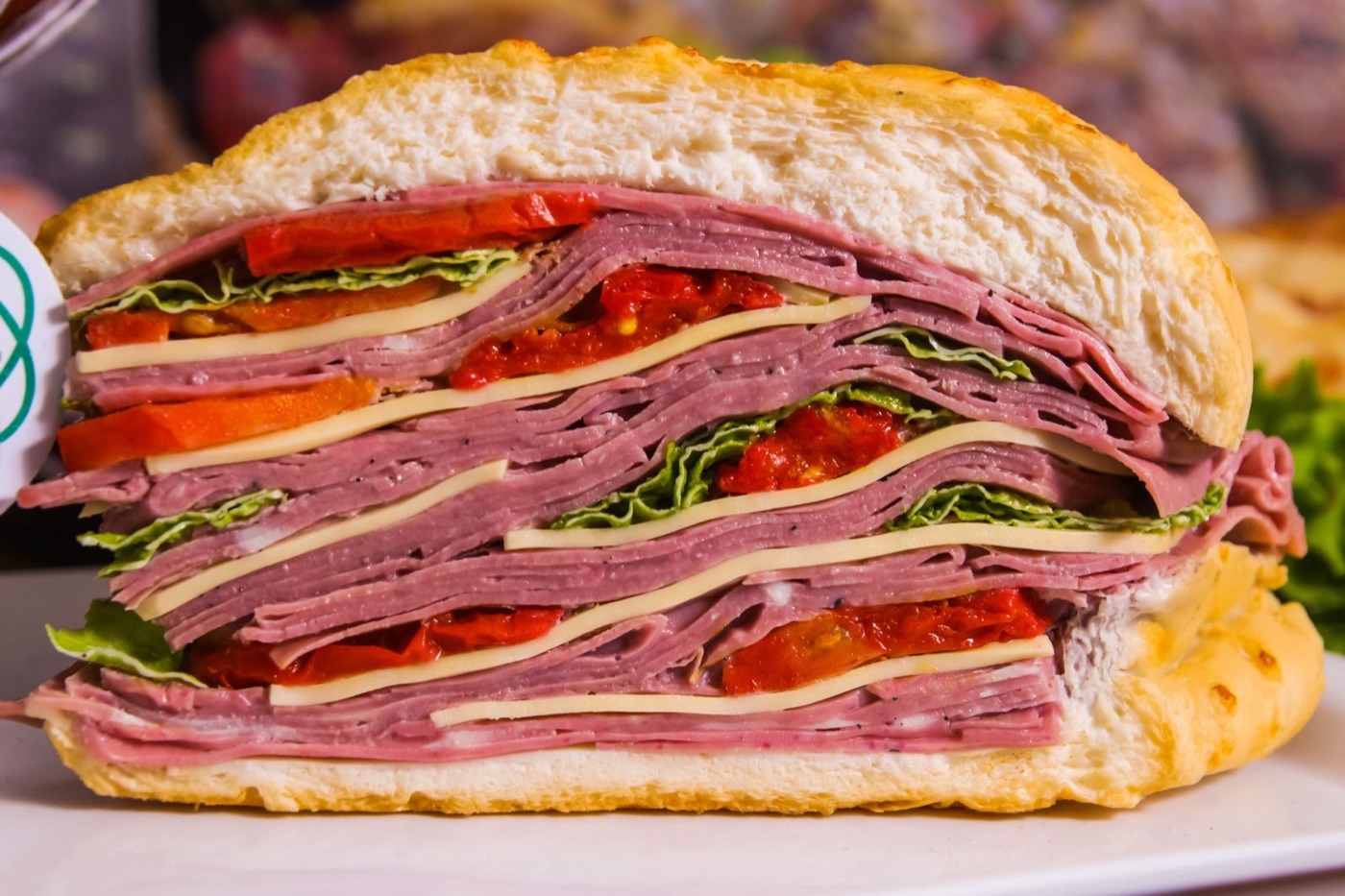 Stacked deli sandwich with layered meats and cheese