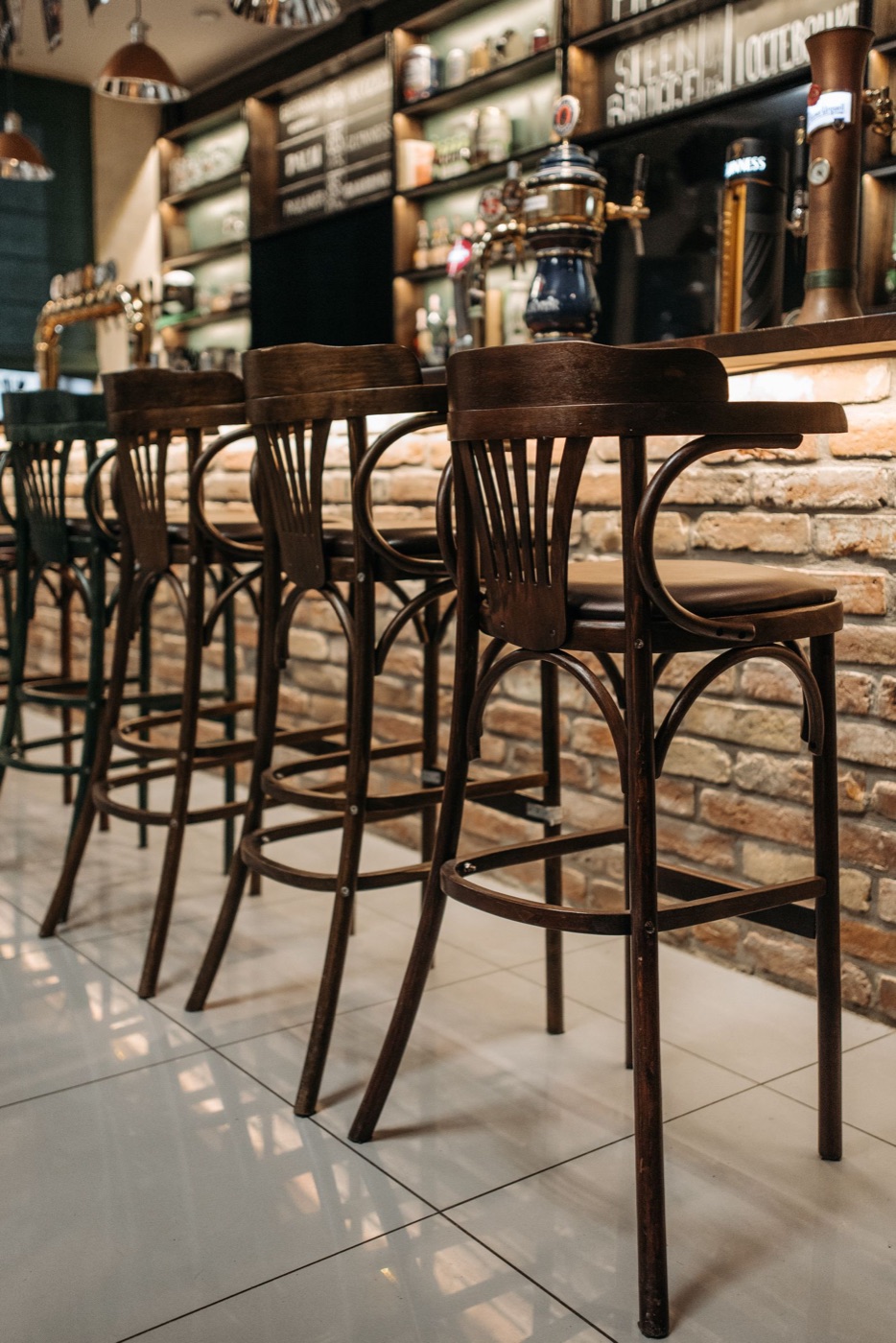Cozy bar interior with wooden stools and a brick counter